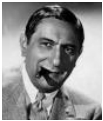 Photographie du cinéaste Ernst Lubitsch souriant avec un gros cigare à la bouche.