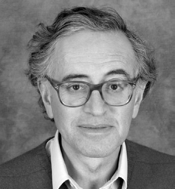 Portrait photographique de Daniel Oppenheim, en costume sombre et lunettes.