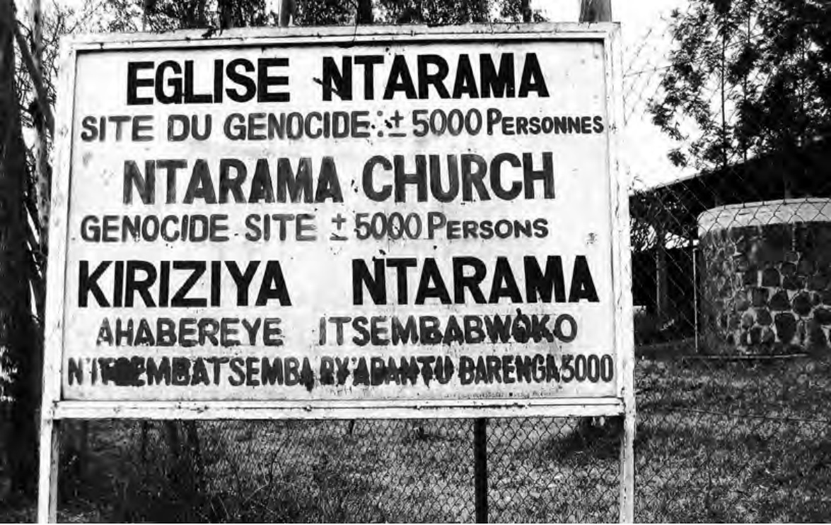 Panneau commémoratif trilingue à l'entrée d'un site mémoriel rwandais indiquant : Église Ntarama, site du génocide, environ 5000 personnes.